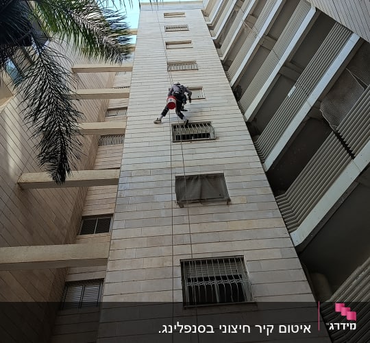 אדם מטפס על בניין גבוה עם חבלים